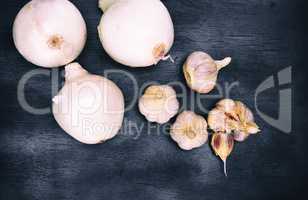 fresh white onion and garlic fruits on a black background, top v