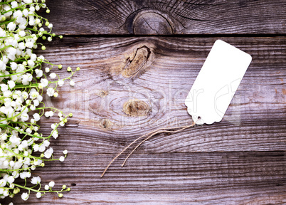 empty white paper tag with a rope on a gray wooden background,