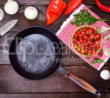 empty black cast-iron frying pan with a wooden handle