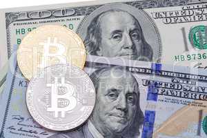 Closeup of golden  and silver bitcoin on hundred dollars banknot