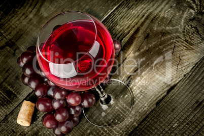 Glass of red wine with grapes