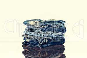A pile of jeans on the shelf of the store or on the table. Reflection. The concept: the sale in the store
