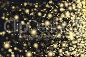 Golden snowflakes swirling on a black background.