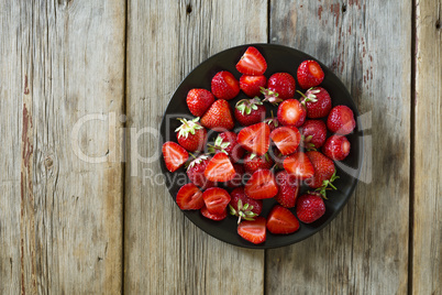 Ripe and delicious strawberries on a plate closeup, top view