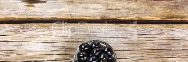 Black olives on a wooden background. View from above