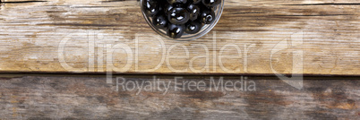 Black olives on a wooden background. View from above