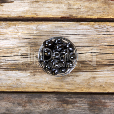 Black olives on a wooden background. View from above