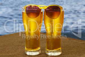 Beer in glasses against the background of the ocean or the sea. Concept: rest by the sea, vacation, travel.