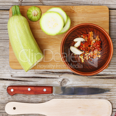 Healthy eating, vegetarian food. Raw zucchini prepared for frying in a frying pan with spices, garlic and greens in olive oil