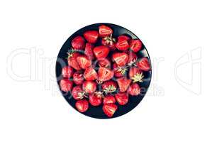 Ripe strawberries in a black plate isolated on white background. Healthy dessert.
