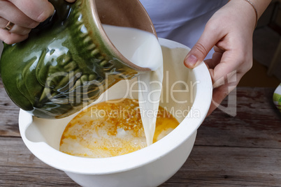 Cooking food. Woman cook pours milk in a bowl. Bakery products.