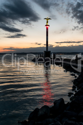 Lighthouse on lake at dusk.