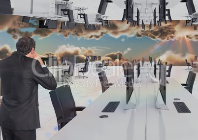 businessman standing in inverted office in the clouds