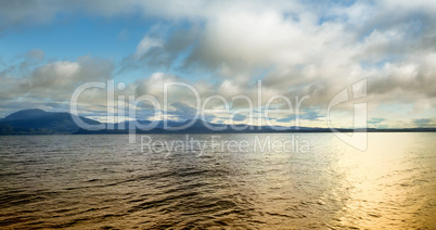 Sea near mountain under cloud