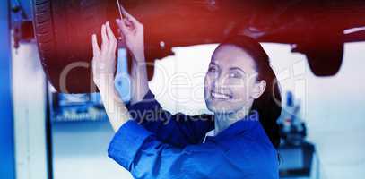 Portrait of smiling mechanic adjusting tire