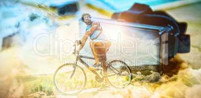 Composite image of fit man cycling on rocky terrain