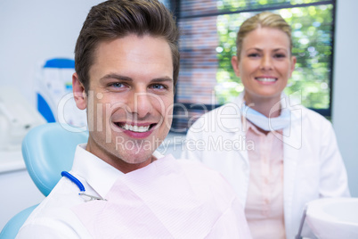 Smiling man and dentist sitting at dental clinic Smiling man and dentist sitting at dental clinic