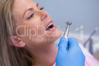 Cropped image of dentist holding medical equipment while giving treatment to patient