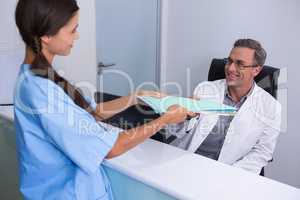 Patient giving files to dentist