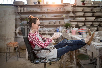 Woman sitting on chair checking bowl