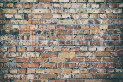 wall of red brick with a layer of gray cement