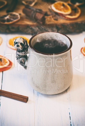 cup of hot tea with steam on white wooden surface