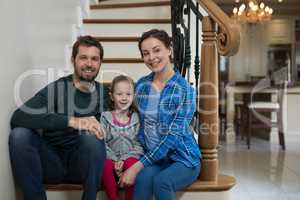 Parents and daughter sitting on stairs