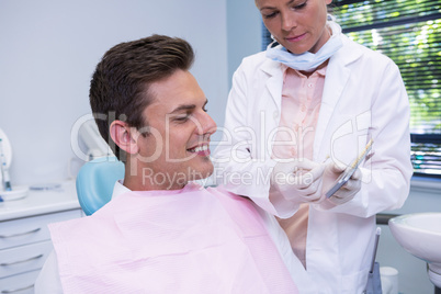 Dentist showing digital tablet to patient