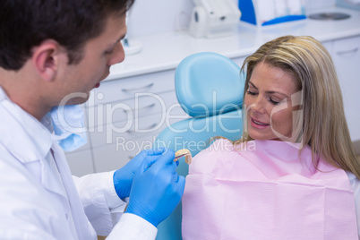 Dentist showing dentures to patient