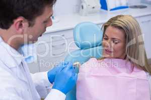 Dentist showing dentures to patient