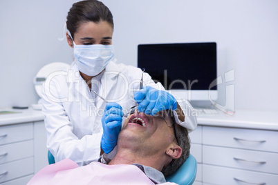 Doctor giving dental treatment to patient at clinic