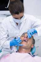 Dentist examining senior man mouth at medical clinic