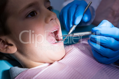 Dentist giving dental treatment to boy at clinic