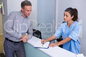 Doctor showing document to man at desk