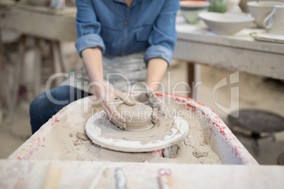 Mid section of female potter molding clay