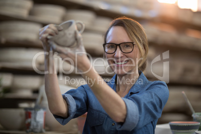 Portrait of female potter making cup