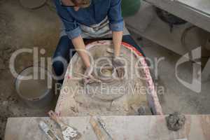 Overhead of female potter molding a clay