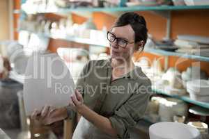 Female potter checking ceramic vase