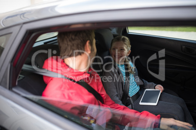 Father and daughter interacting in the back of the car
