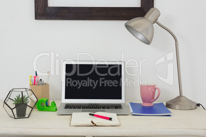 Laptop and various office accessories on table