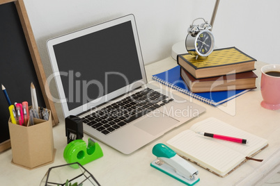 Laptop and various office accessories on table