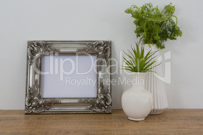 Picture frame and vase on table