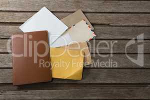 Various envelopes and diary on wooden plank