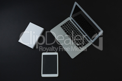 Laptop, digital tablet and organizer on black background