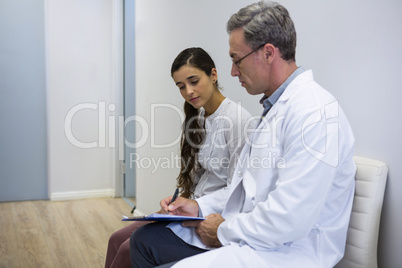 Dentist and patient discussing while sitting on sofa