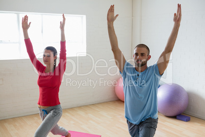 Instructor with student practicing warrior 1 pose in yoga studio