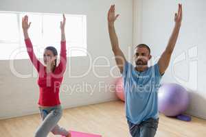 Instructor with student practicing warrior 1 pose in yoga studio