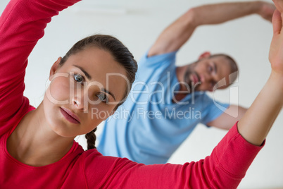 Female student with instructor exercising in health club