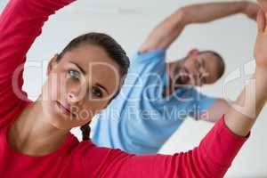 Female student with instructor exercising in health club