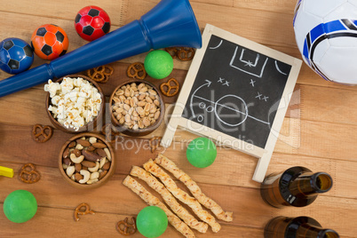 Strategy board, snacks, drink and football on wooden table